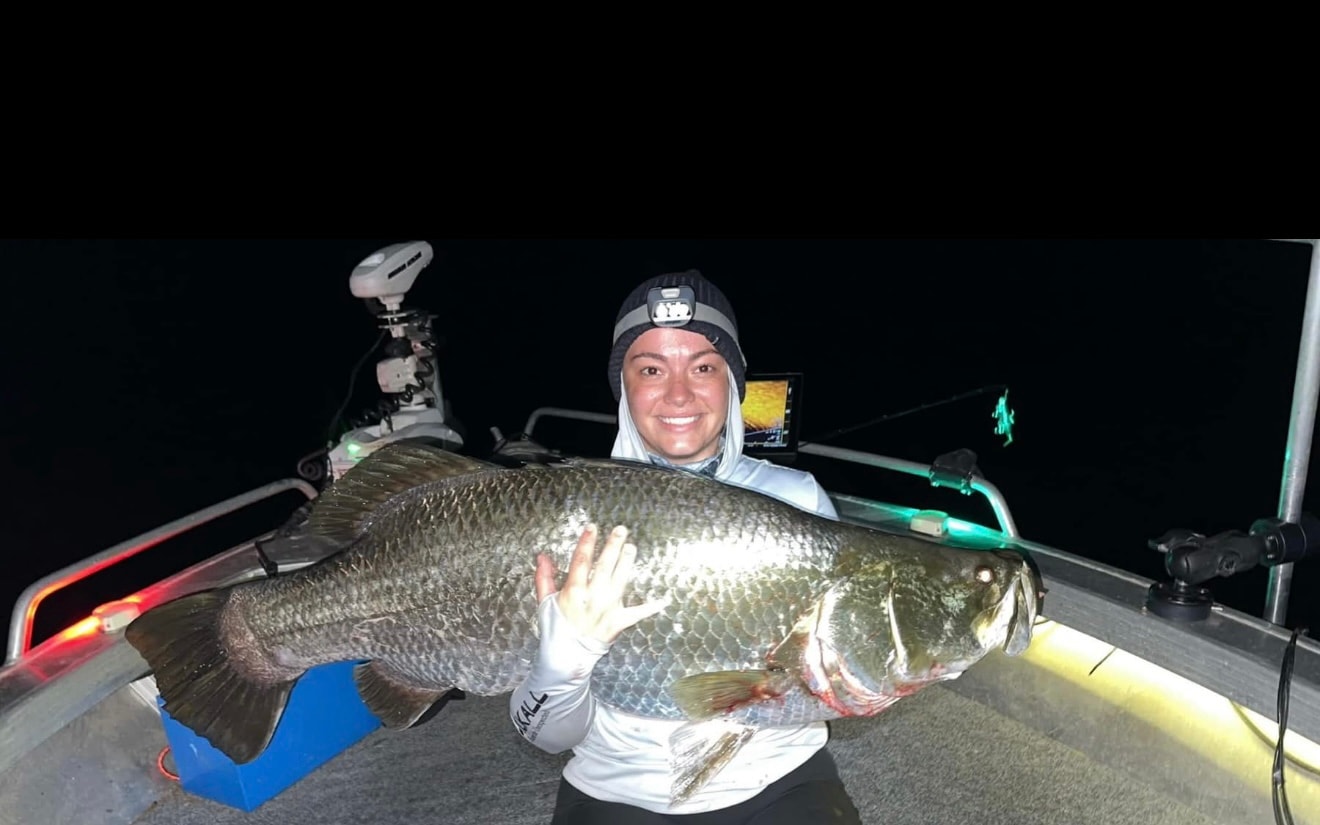 Zoe, co-founder of Cutlass, with a barramundi at night